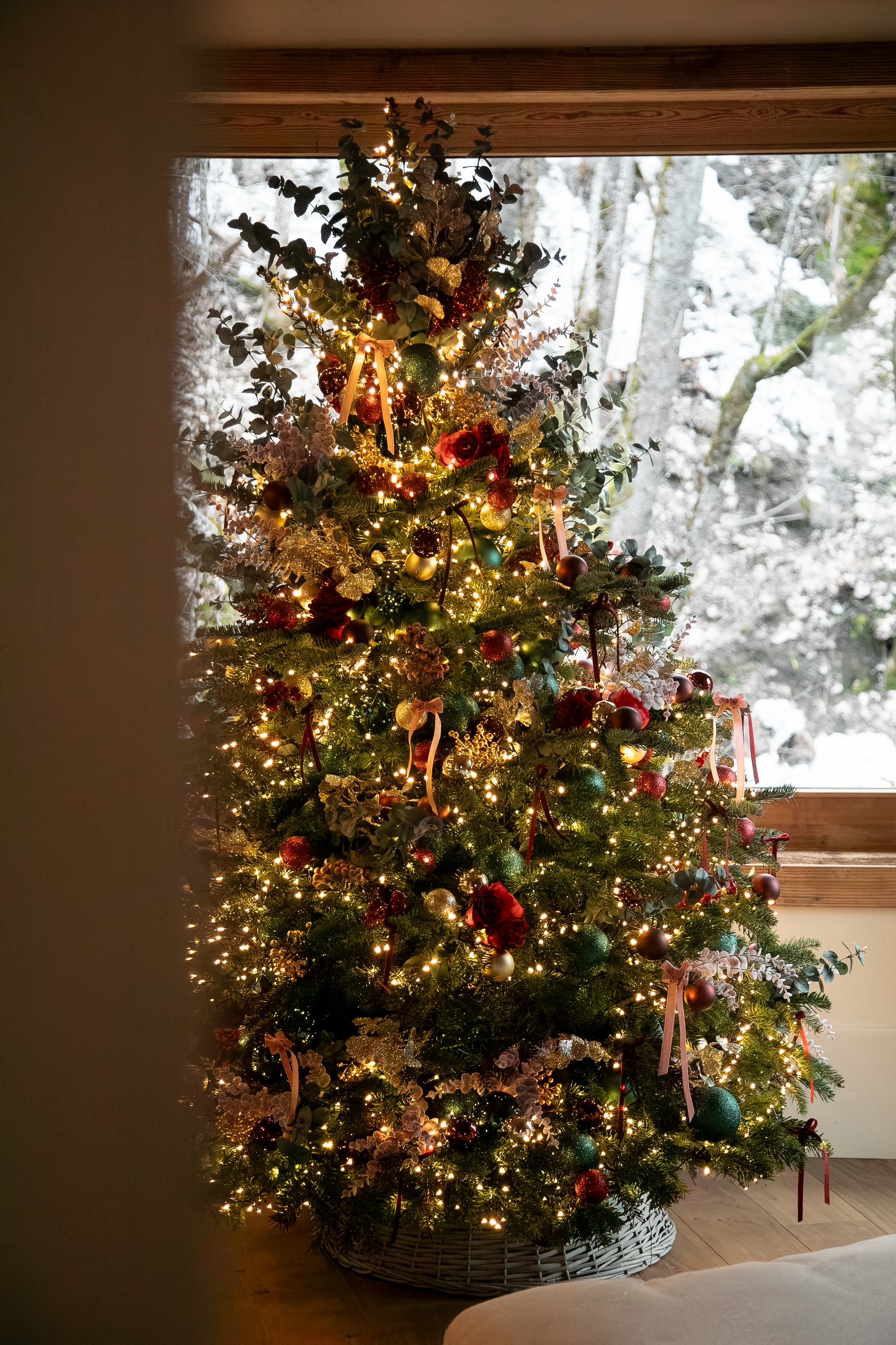 A candlelit Christmas tree in an alpine chalet