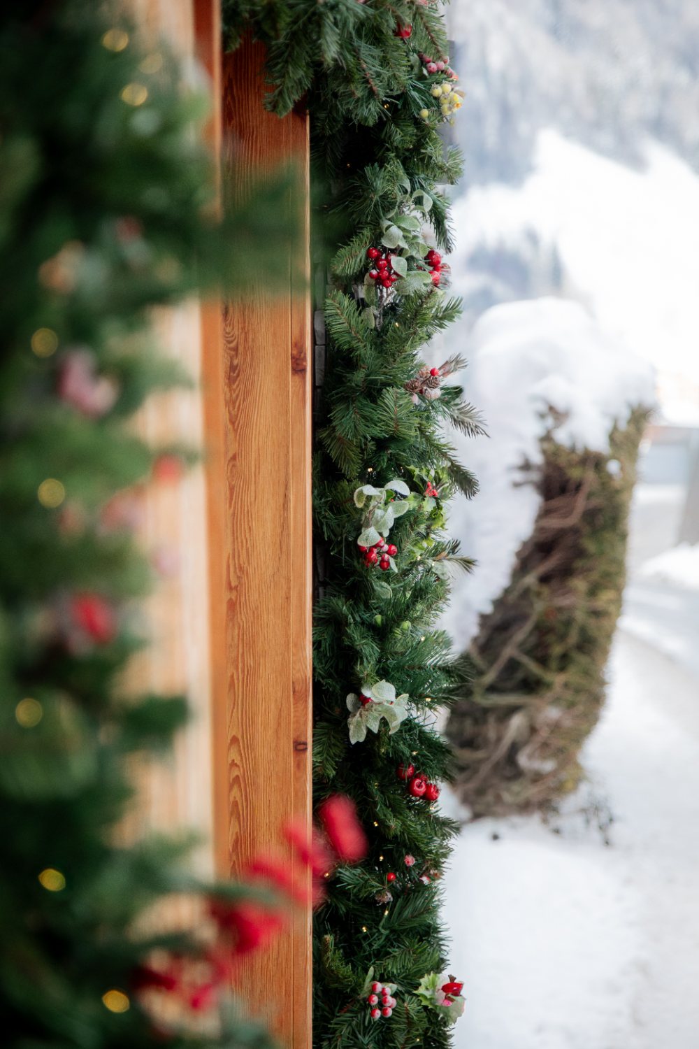 Berry garland against the timber, snow beyond
