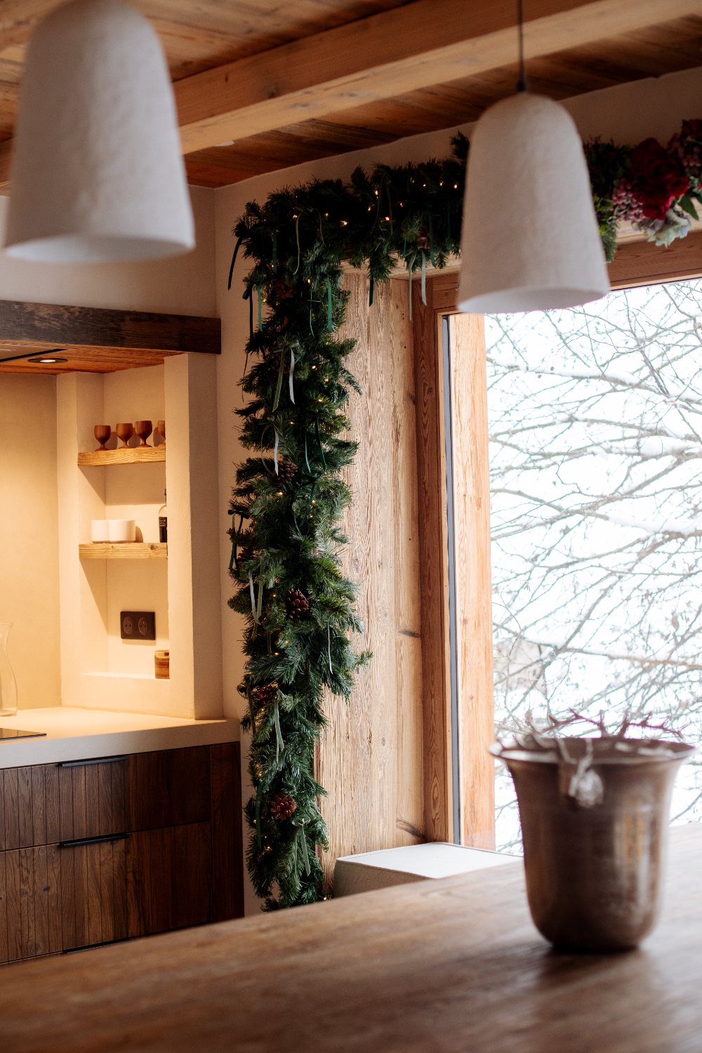 Kitchen framed by garland and snow-filled window